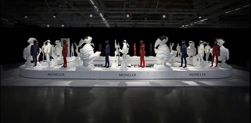 Allestimento espositivo Moncler con manichini in piumino su pedana bianca