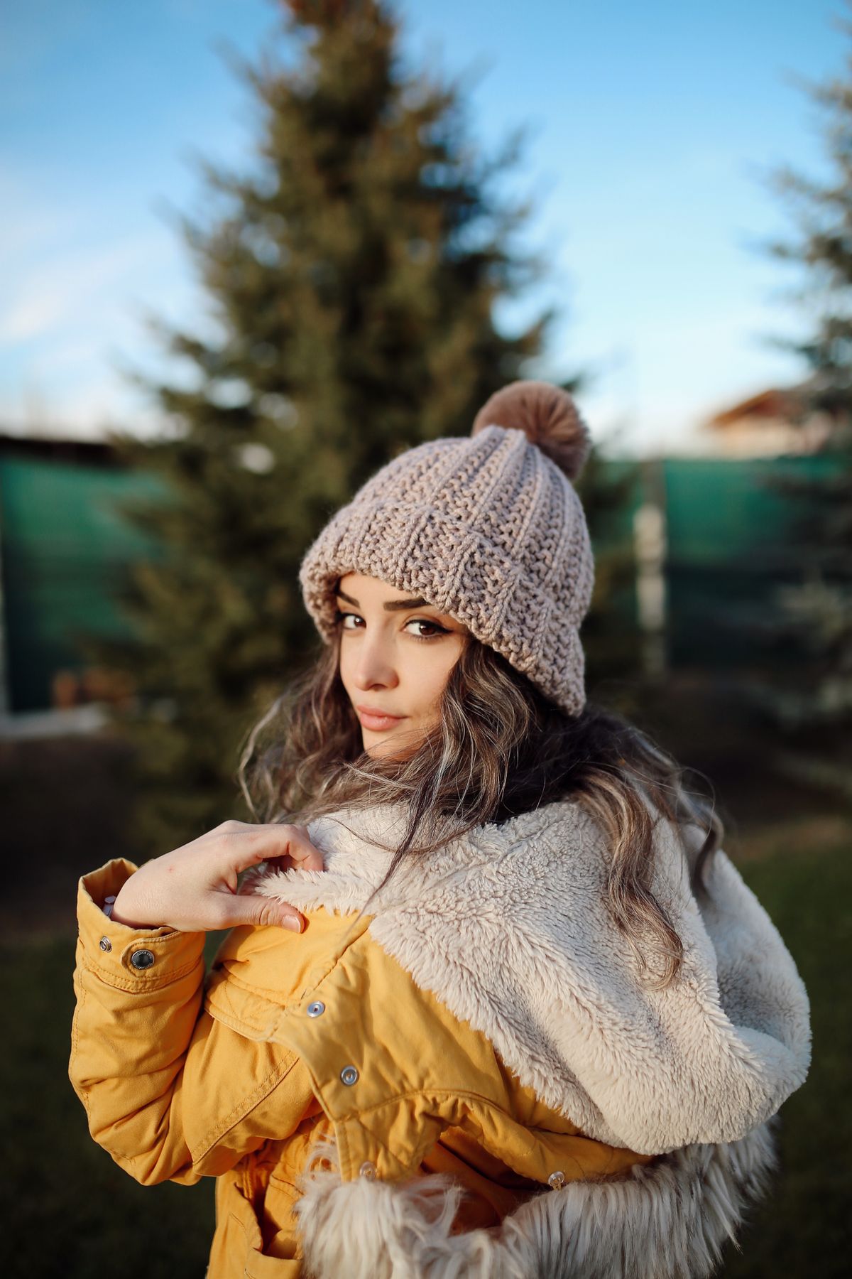 Donna con berretto in lana con pompon, accessori invernali di tendenza 2026-2027