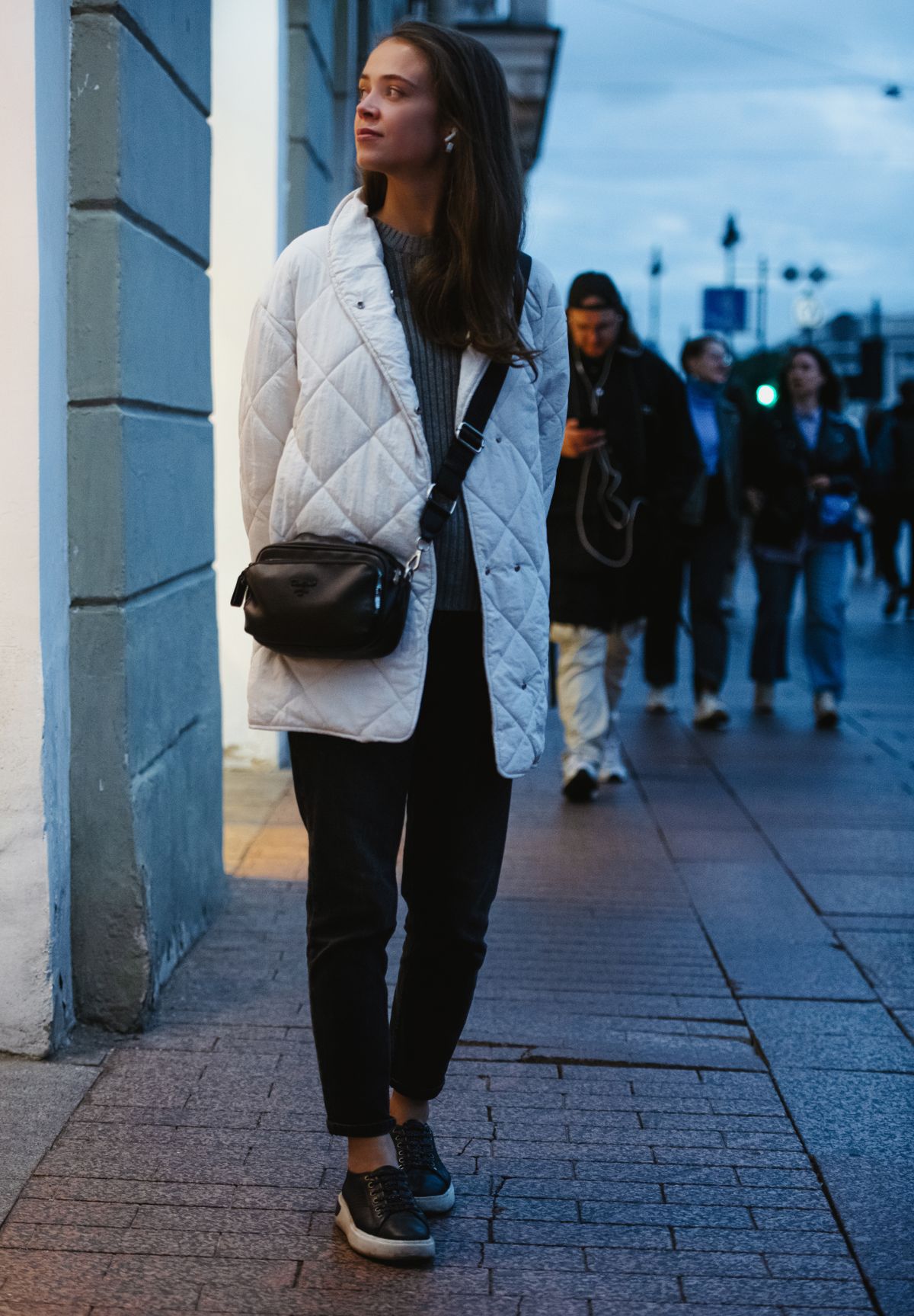Borsa a tracolla nera piccola indossata a tracolla in stile street style invernale