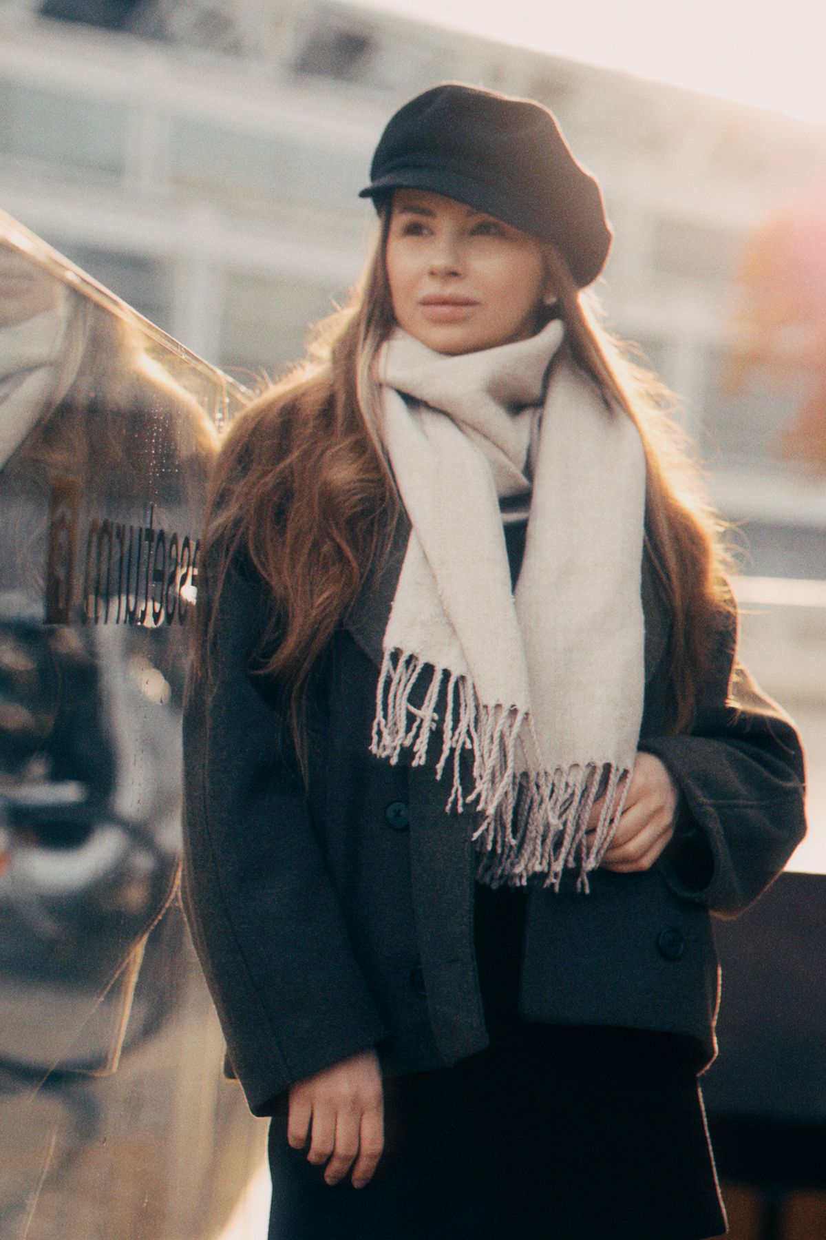 Donna con cappello baker boy e sciarpa in lana con frange, tendenze inverno 2026-2027
