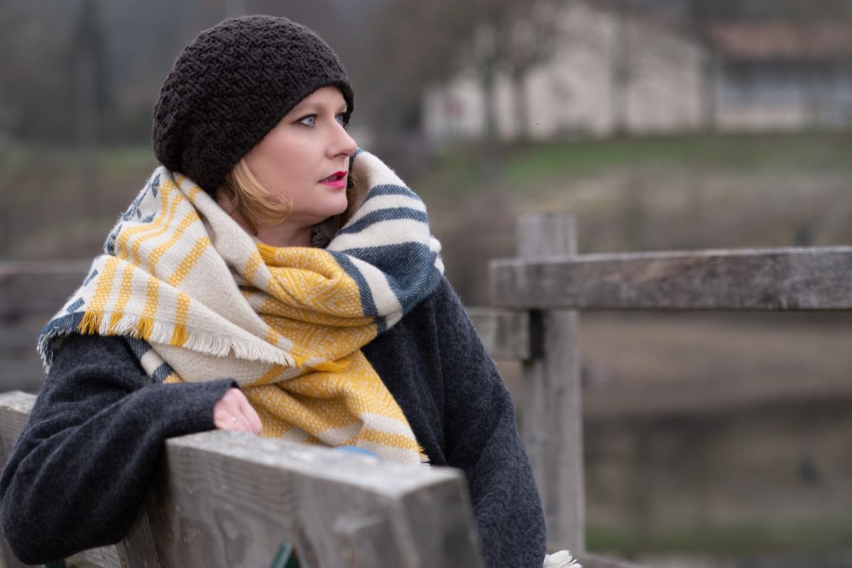 Donna con berretto in lana e sciarpa maxi a quadri, accessori invernali 2026-2027