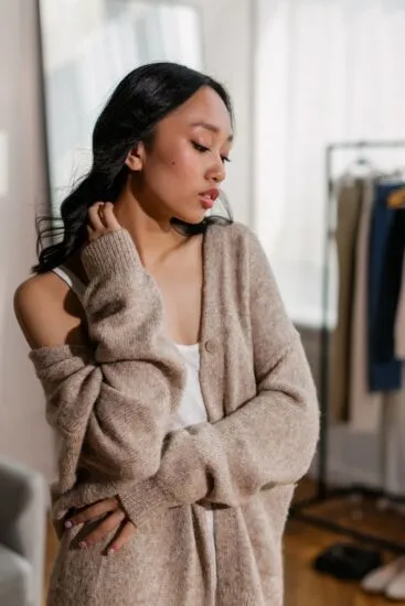 Cardigan donna oversize beige abbottonato sopra un top bianco, inverno 2026-2027