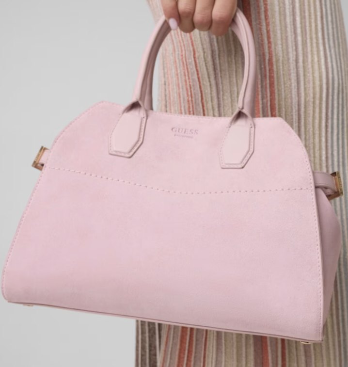 Pink suede-look Guess handbag with the GUESS lettering on the front, held by the top handles