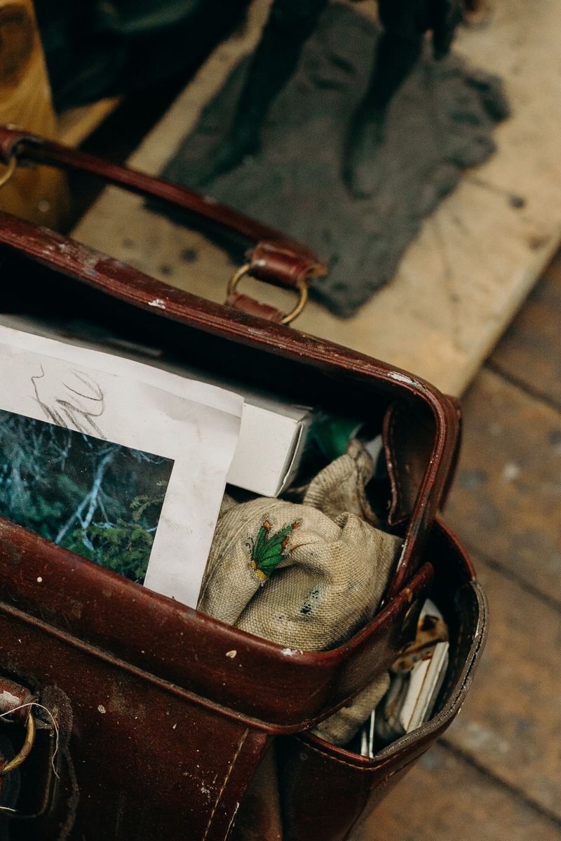 Open leather bag with papers and gloves left inside