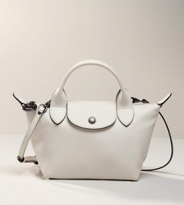 Small chalk-coloured Longchamp leather handbag with short handles, removable strap and the flap closed on the press stud