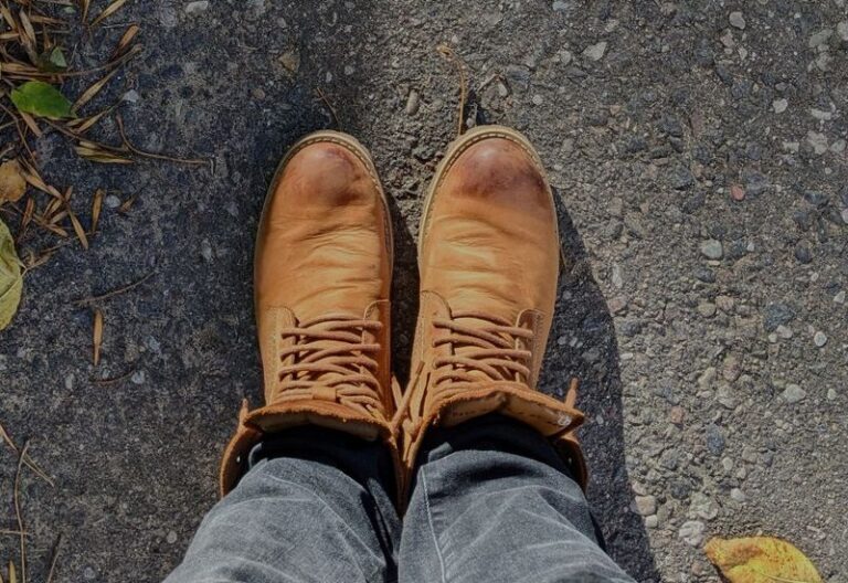 Tan leather lace-up boots seen from above with flex creases across the toe
