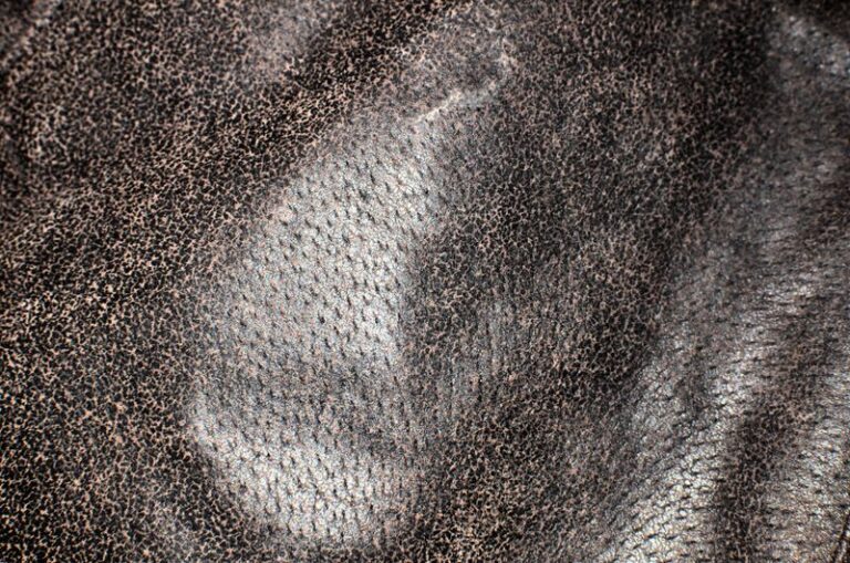 Close-up of natural leather grain with pores of uneven size and spacing, the first thing to check when working out how to tell if leather is real